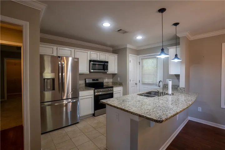 Polished granite countertops and classic crown molding accent this inviting culinary space.