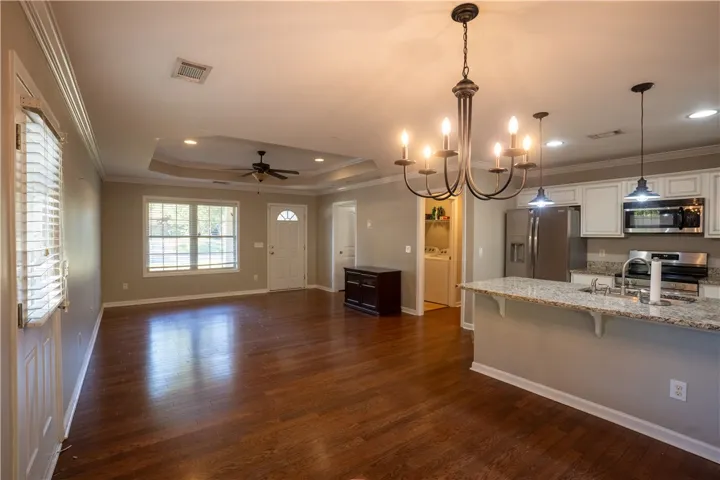 Gleaming hardwood floors and classic crown moldings enhance this versatile open-concept living space.