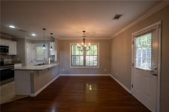Gleaming hardwood floors and classic crown molding anchor this open dining space.