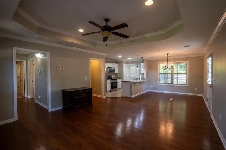 Gleaming hardwood floors and an elegant tray ceiling define this open-concept main level living area.