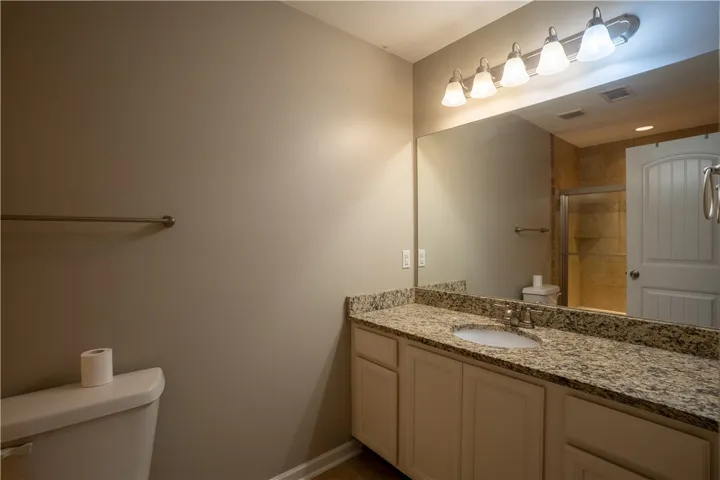 Granite counters and integrated lighting elevate this bathroom space.