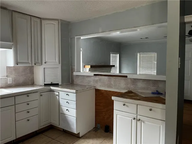 An open pass-through window connects the kitchen workspace to the adjacent living area.