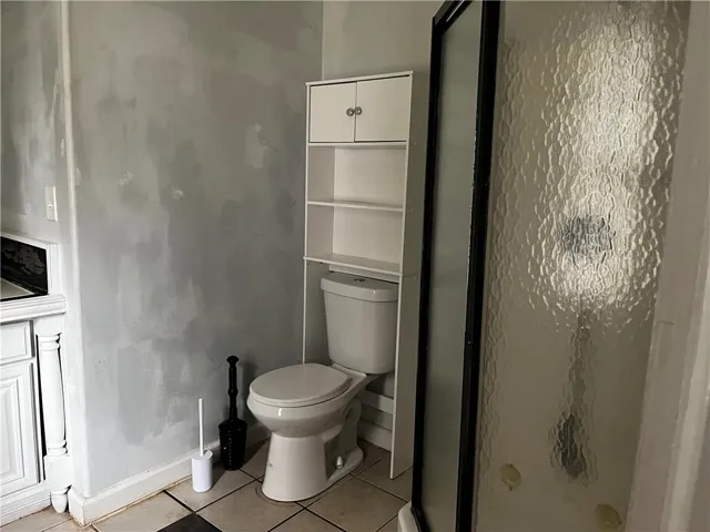 Tiled flooring and a glass-enclosed shower define this functional bathroom space.