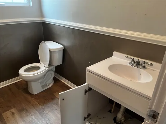 Classic chair rail molding and durable wood-look flooring define this functional half bathroom.