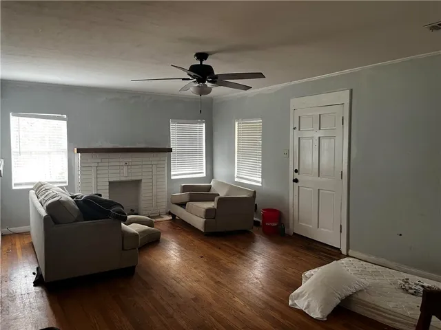 A classic brick fireplace centers this inviting living room accented by rich hardwood flooring.