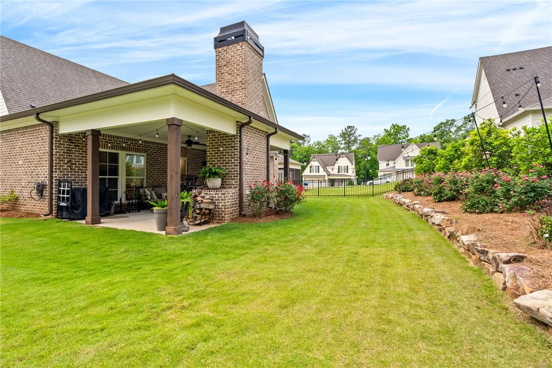 Back of the home, with a covered patio and a big grassy yard.