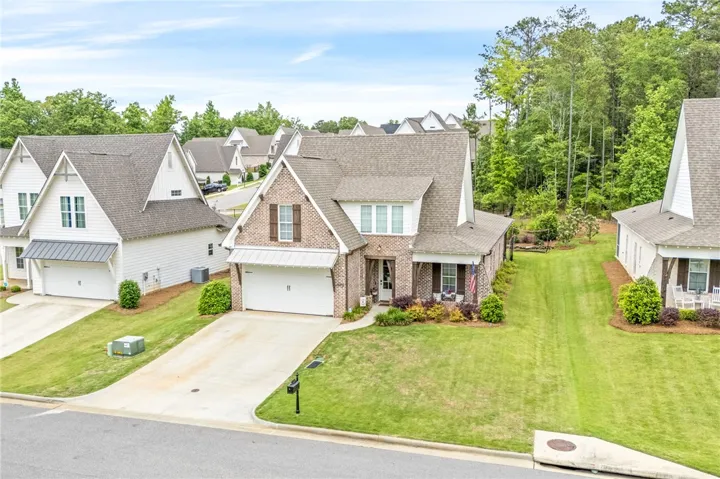 Another angle of the front, with a well-kept lawn and mature trees.