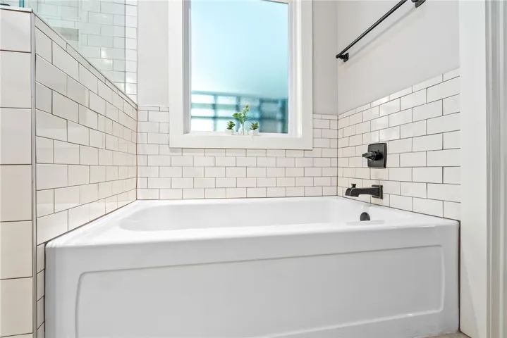 Soaking tub with subway tile surround and a privacy window.
