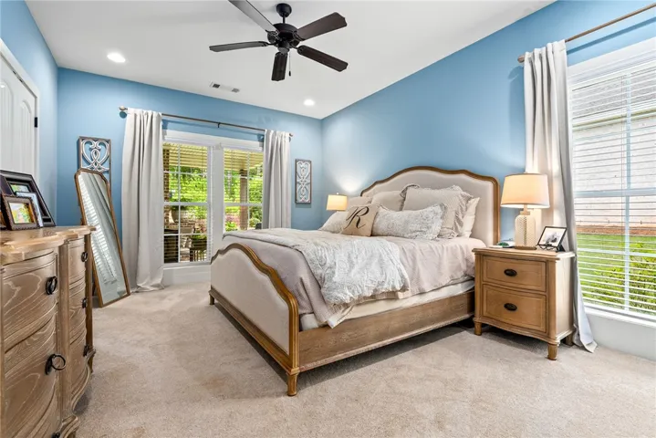 Primary bedroom with a ceiling fan and plenty of natural light.