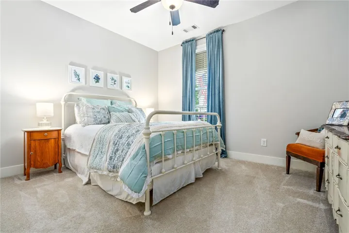 Guest bedroom with carpet and a large window.