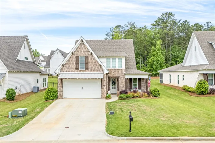 Front of home with brick and siding, a two-car garage, and a wide driveway.