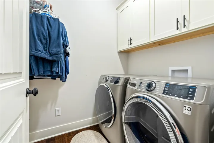 Laundry room with upper cabinets and a hanging rod.