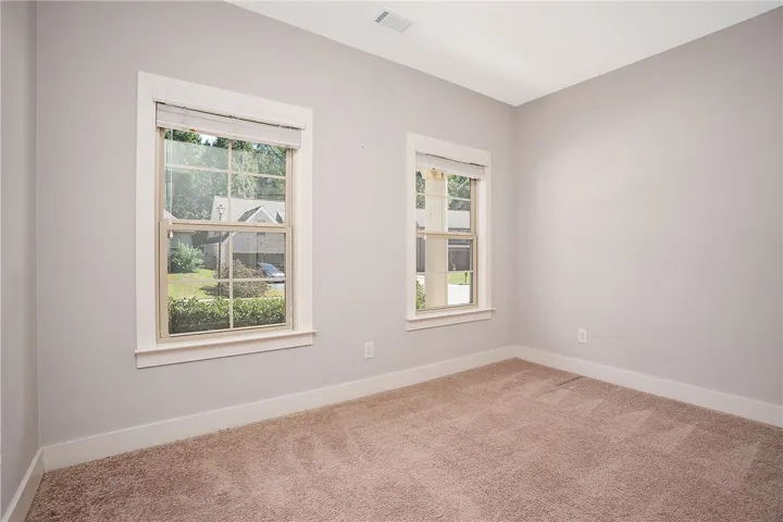 Plush carpeting and multi-pane windows define this versatile secondary bedroom space.