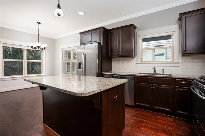 Rich wood floors and elegant granite counters elevate this well-appointed kitchen workspace.