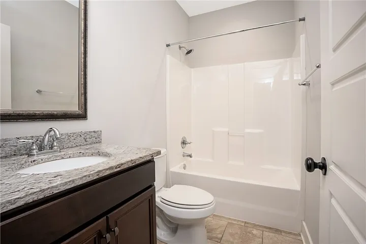 Polished granite counters and classic tile floors highlight this functional bathroom space.
