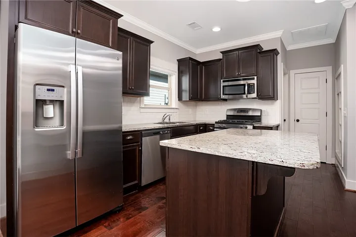 Rich dark wood cabinetry contrasts beautifully with granite countertops and classic hardwood flooring.