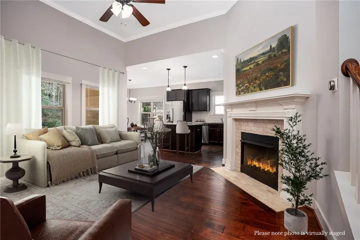 Rich hardwood flooring complements a classic fireplace beneath towering ceilings in this inviting open space.