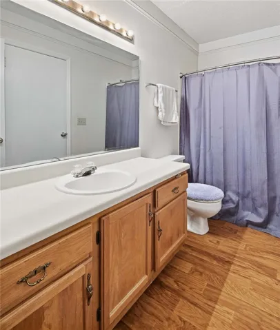 Warm wood cabinetry and classic fixtures define this comfortable bathroom space.