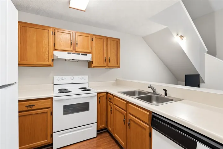 Classic oak cabinetry and laminate countertops define this functional kitchen layout.