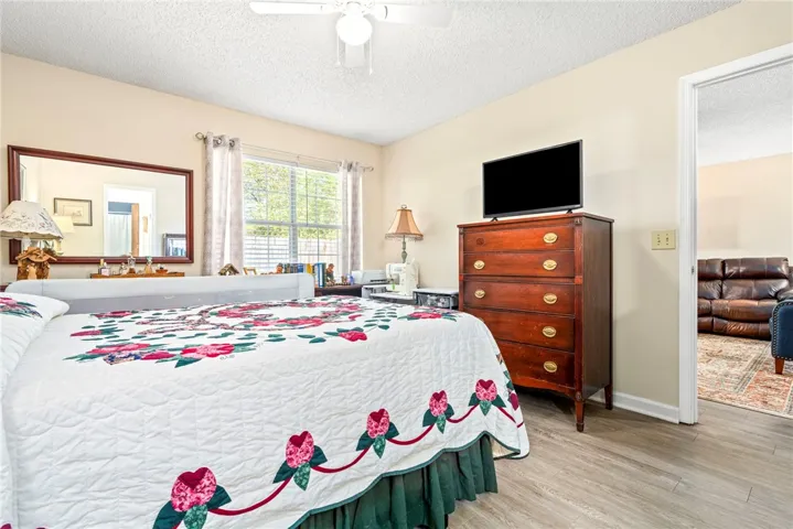 Plentiful natural light fills a versatile bedroom featuring durable hard surface flooring and wide trim.