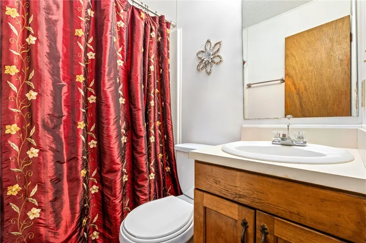 A classic wooden vanity adds warmth and functional storage to this tidy bathroom.