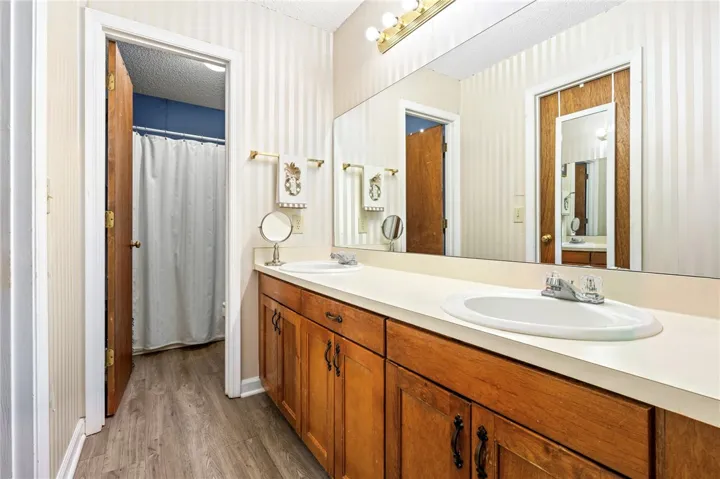 Warm wood cabinetry and classic dual sinks define this functional bathroom layout.