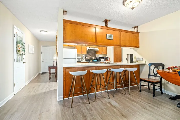 Smooth wood-look flooring anchors this open floorplan seamlessly connecting the entry hall and dining areas.
