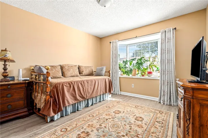 Warm natural light streams through a classic bay window onto durable vinyl plank flooring.