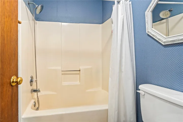 A classic shower and tub combination provides functional simplicity in this bathroom space.