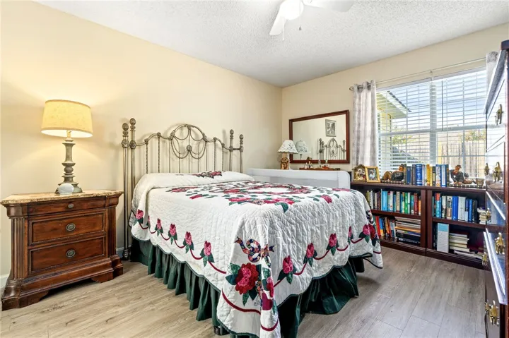Natural light streams through a large window, highlighting the warm wood flooring throughout the room.