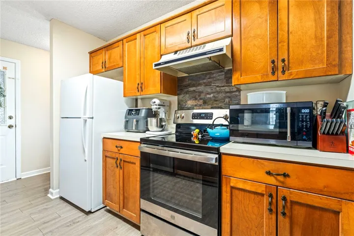 Warm wood cabinetry and durable flooring create a classic and functional culinary environment.