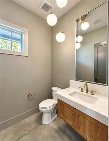 A stone counter vanity with modern fixtures highlights this sleek bathroom layout.