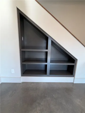 Custom built-in shelving maximizes storage space underneath the modern staircase.