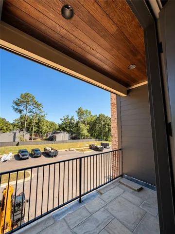 Rich wood plank ceilings and flagstone flooring elevate this private covered balcony.