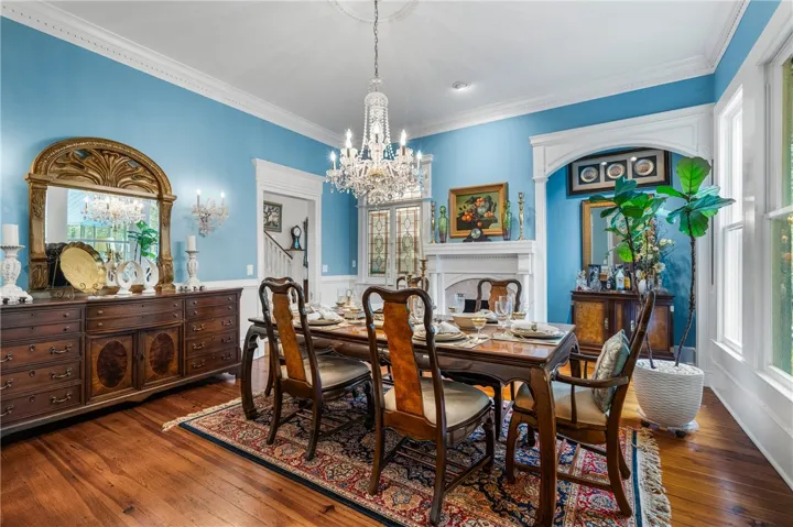 Gleaming hardwood floors, crown molding, and a classic fireplace anchor this elegant formal dining room.