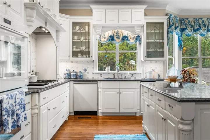 Fine cabinetry and polished countertops highlight this classic workspace overlooking a verdant backyard view.