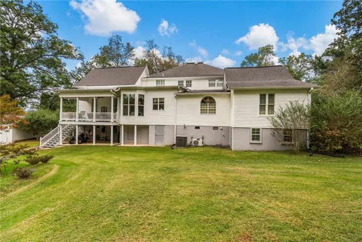An expansive green lawn rolls up to the multi-level rear exterior of this classic home.