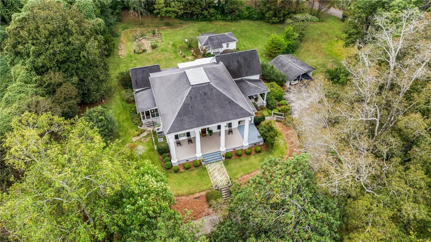 An aerial perspective showcases the sweeping estate nestled among mature trees and lush green lawns.