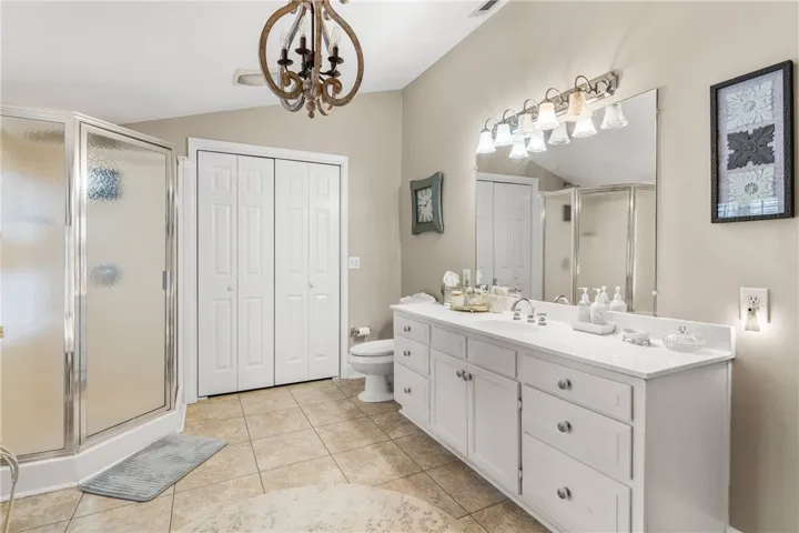 Neutral tiled floors and a spacious white vanity complete this well-appointed bathroom.