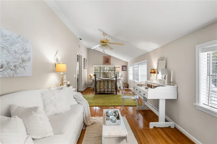 Rich hardwood flooring complements the vaulted ceiling in this spacious, well-lit bedroom suite.