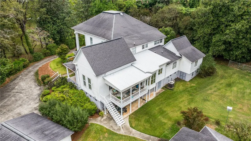 A spacious multi-level estate rises amidst lush green lawns and mature trees.