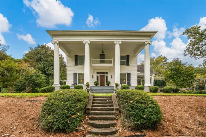 Grand columns frame a majestic two-story portico leading to the elegant front entryway.