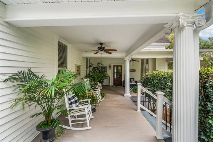 Classic columns and painted wood decking frame a welcoming, deep covered veranda.