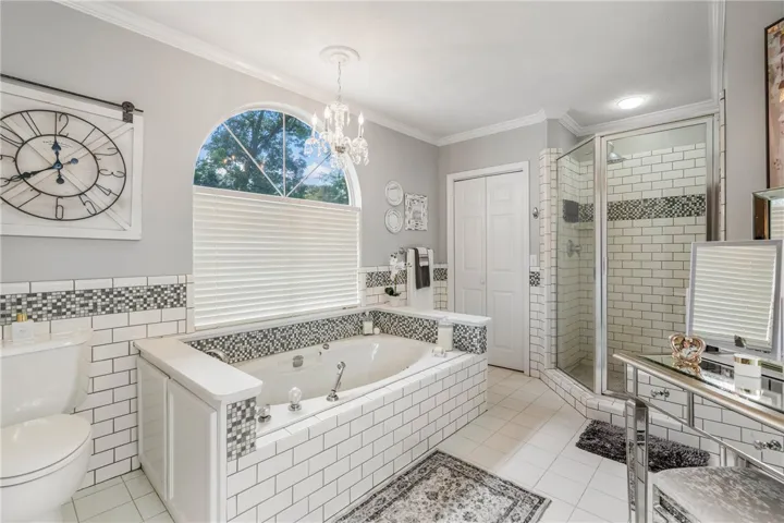Timeless subway tile surrounds a built-in soaking tub beneath an arched window.