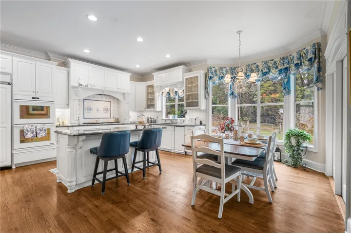 Gleaming hardwood floors and classic crown molding anchor this open kitchen and dining space.