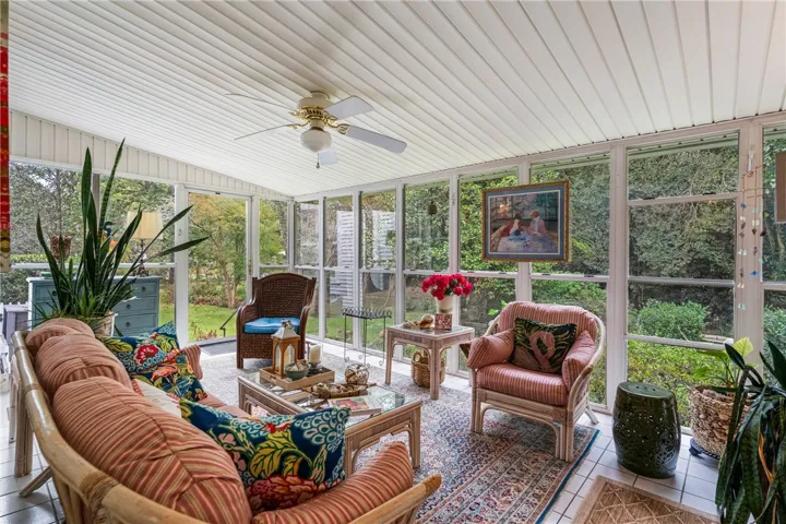 Walls of glass wrap this sunroom, offering views of the surrounding garden landscape.