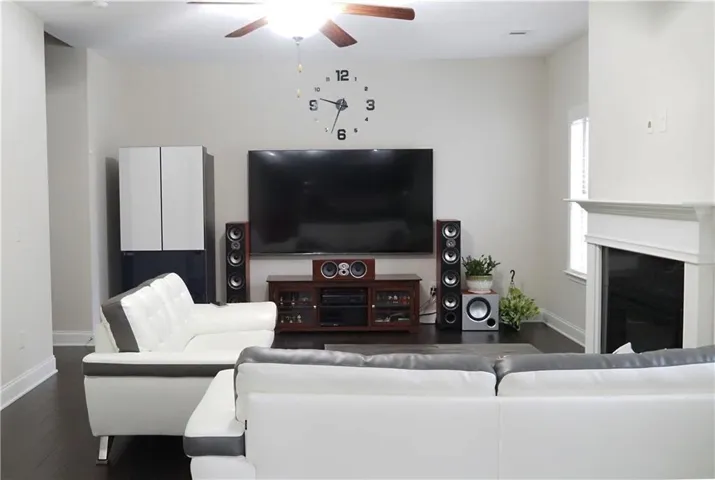 Rich dark wood flooring and a classic fireplace mantel anchor this comfortable living space.