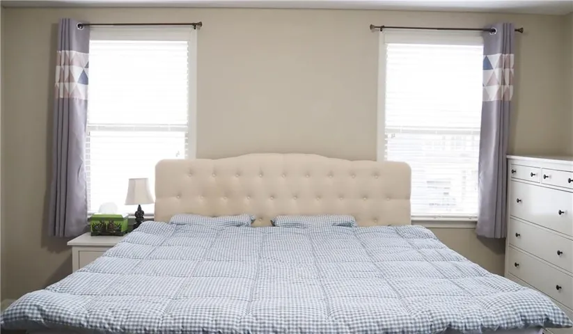 Symmetrical double windows frame the bed wall, inviting soft natural light into the space.