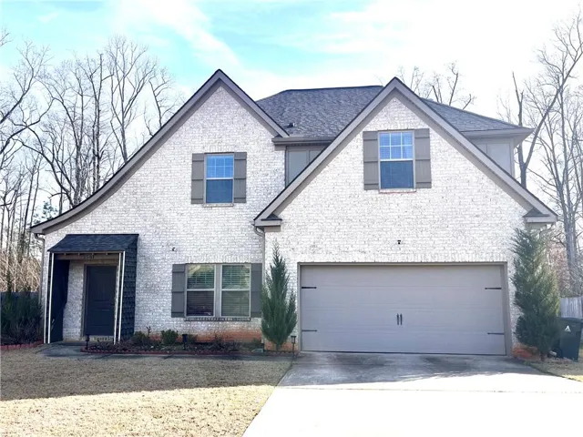 Gabled rooflines and classic brickwork define this stately two-story home with a two-car garage.