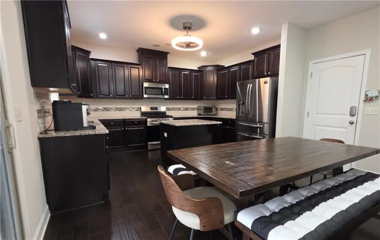 Rich dark wood cabinetry and matching flooring define this open culinary and dining space.